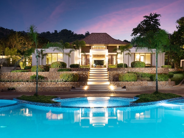 Moderne Ferienanlage mit Pool, Eingangstreppe und gepflegter Gartenanlage.