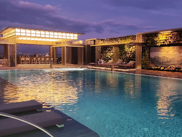 Poolbereich mit Liegestühlen und einer Bar.