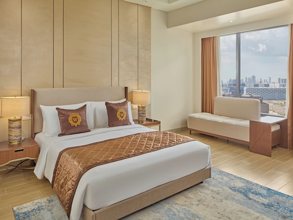 Modernes Hotelzimmer mit großem Bett, Sitzecke und Stadtblick.
