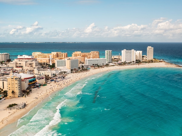 Küstenstadt mit Strand, Hotels und klarem blauem Meer.