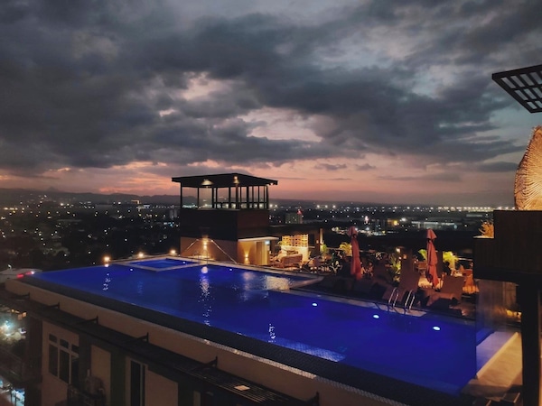 Dachpool mit Stadtblick in der Abenddämmerung.